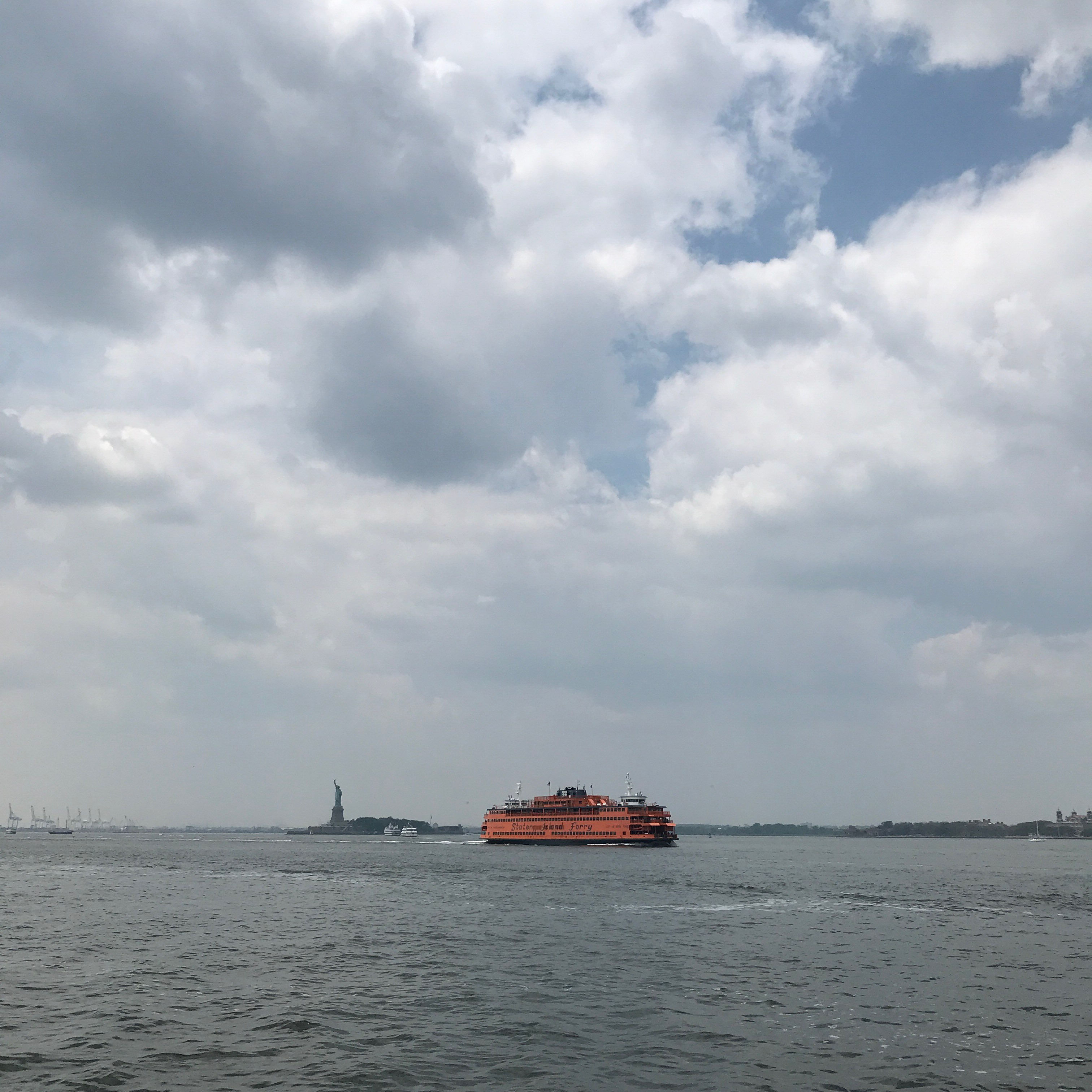Whitehall bound Staten Island Ferry seen from the Governors Island Ferry, the Statue of Liberty in the distance