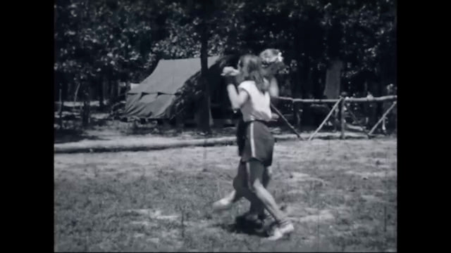 Black and white footage of girl campers dancing
